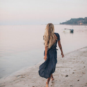 photo of woman walking on seashore 2072583